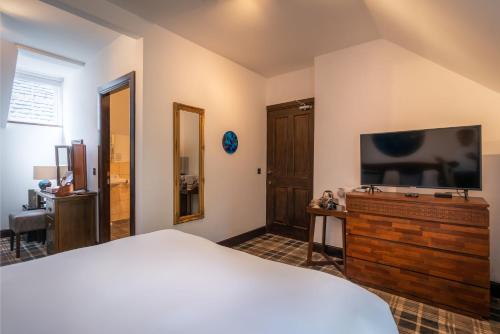 a bedroom with a bed and a flat screen tv at Edinbane Lodge in Edinbane