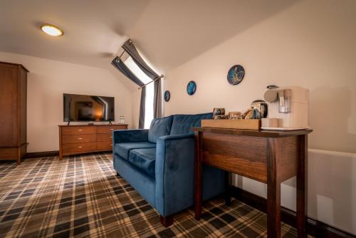 a living room with a blue couch and a table at Edinbane Lodge in Edinbane