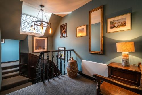 a hallway with a staircase and a mirror at Edinbane Lodge in Edinbane