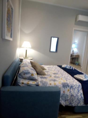 a bedroom with a bed with a blue couch at Case Vacanza Le Casette in Santo Stefano di Camastra