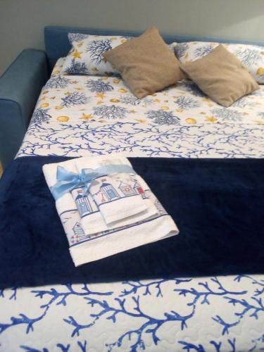 a bed with a blanket and a book on it at Case Vacanza Le Casette in Santo Stefano di Camastra