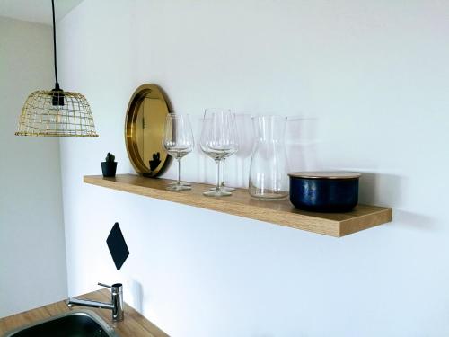 a shelf with wine glasses and a mirror on a wall at Marina Strand Appartement Lemmer in Lemmer