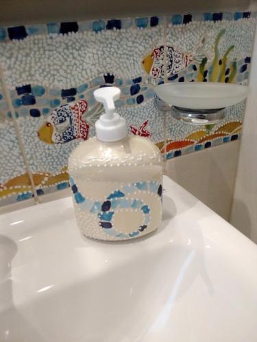a white bottle sitting on top of a sink at Case Vacanza Le Casette in Santo Stefano di Camastra