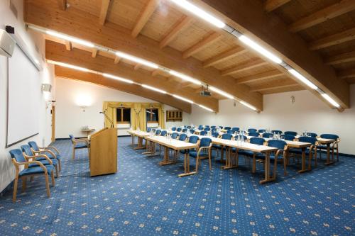 a conference room with tables and chairs and a podium at Hotel Sassongher in Corvara in Badia