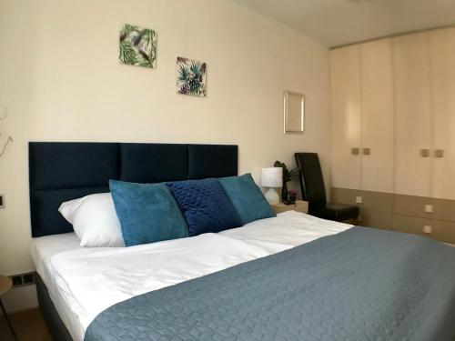 a bedroom with a large bed with blue and white pillows at Stadium Apart in Warsaw