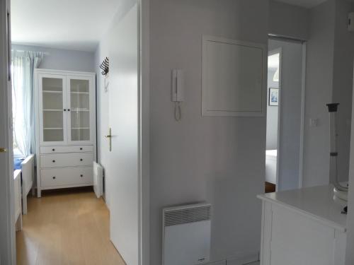 a kitchen with white walls and a white cabinet at Au gré du vent in Camiers