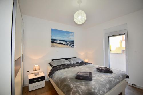 Un dormitorio blanco con una cama grande con dos almohadas. en Apartments Mira, en Pula