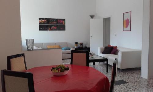 sala de estar con mesa roja y sofá en Vacanza serena en Castrignano del Capo