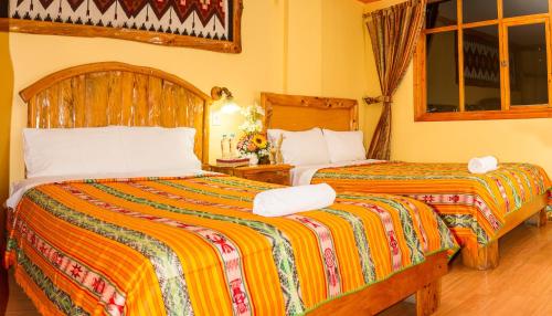 two beds in a hotel room with two beds at Hotel Santafe Inn in Otavalo