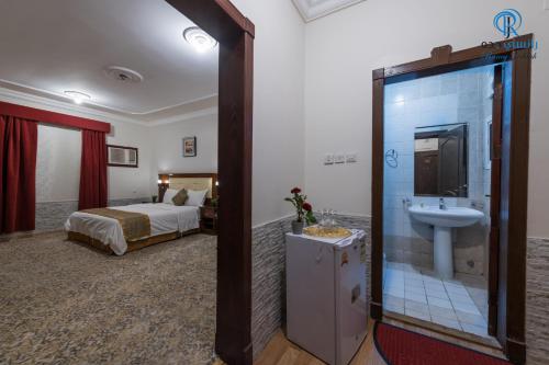 a hotel room with a bathroom with a sink and a bed at Rancy Jeddah Aparthotel in Jeddah