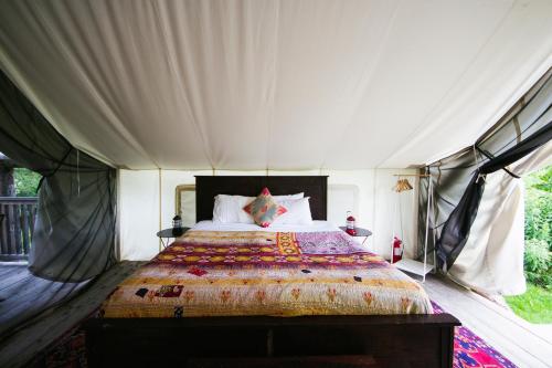 a bedroom with a bed in a tent at Firelight Camps in Ithaca