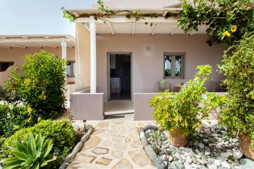 a patio with trees and plants in front of a house at Mythos Suites Diskos in Léntas