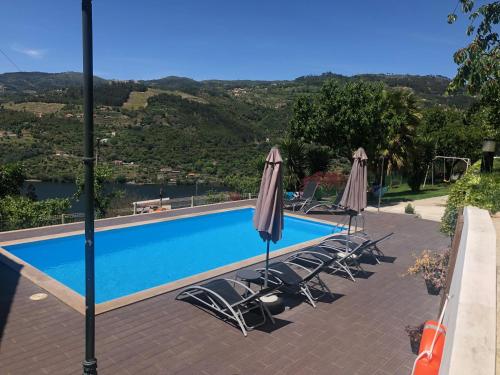 uma piscina com cadeiras e guarda-sóis em Quintinha de Mirão - Douro Valley em Resende