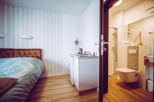 a bedroom with a bed and a sink and a mirror at Willa Atena in Łeba