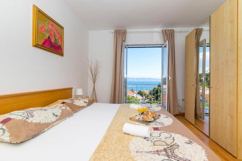 Un dormitorio con una cama y una ventana grande. en Apartments Palma, en Jelsa