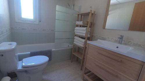 Un baño con inodoro, lavabo y espejo. en Pool, Beach, Golf & Hard Rock in Salou, en Salou