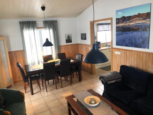 een woonkamer met een tafel en een eetkamer bij Eyjasol Cottages in Reykholt