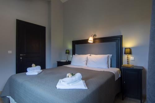 a bedroom with a large bed with towels on it at Villa Elaia Suites & Apartments No.1 in Gaios