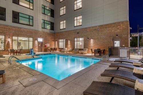 a swimming pool with chairs and a building at DoubleTree by Hilton Charleston Riverview in Charleston