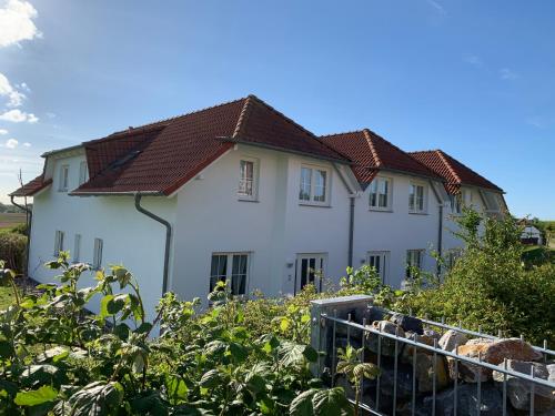a white house with a fence in front of it at Apartment "MS Bernstein" (75m²) im Ferienpark in Sagard
