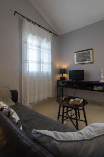 a living room with a couch and a table at Villa Elaia Suites & Apartments No.1 in Gaios