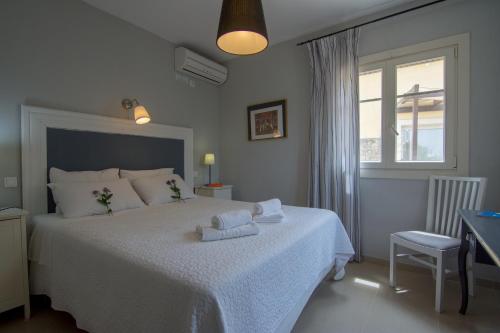 a bedroom with a white bed and a window at Villa Elaia Suites & Apartments No.2 in Gaios