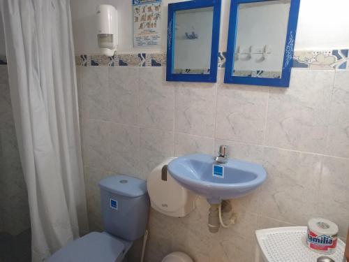 a bathroom with a blue sink and a toilet at Hostal Palohe Taganga in Taganga