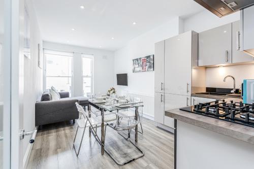 cocina y sala de estar con mesa y sofá en 2-bed Notting Hill / Portobello, en Londres