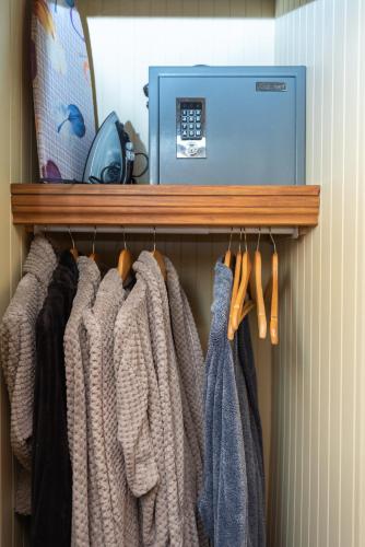 a row of sweaters are hanging on a shelf at Auberge Le Four à Pain in Petite-Rivière-Saint-François