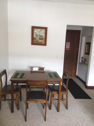 a dining room table and chairs with a picture on the wall at Suites Parque Real in Quito