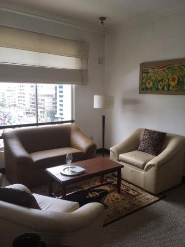 a living room with two couches and a coffee table at Suites Parque Real in Quito