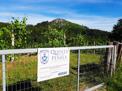 a sign on a fence with a mountain in the background at Quinta Da Penela in Vieira do Minho