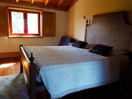 a bedroom with a large bed and a window at Quinta Da Penela in Vieira do Minho