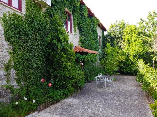 a garden with a table and chairs in front of a building at Quinta Da Penela in Vieira do Minho