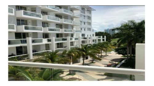 a large white building with palm trees in front of it at Playa Blanca in Playa Blanca