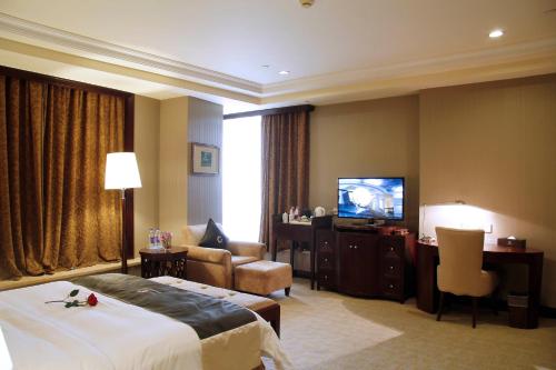 a hotel room with a bed and a flat screen tv at The Royal Marina Plaza Hotel Guangzhou in Guangzhou
