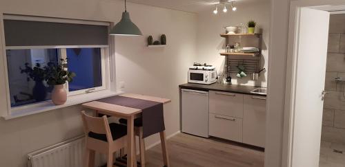 a small kitchen with a table and a microwave at Gunnlaugsgata 3 in Borgarnes
