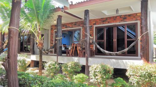 a house with a front porch with trees and plants at Lanta New Coconut Bungalow in Ko Lanta