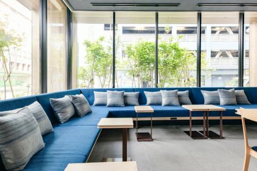 a blue couch in a room with windows at Vessel Hotel Campana Susukino in Sapporo