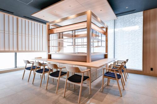 a dining room with a wooden table and chairs at Vessel Hotel Campana Susukino in Sapporo