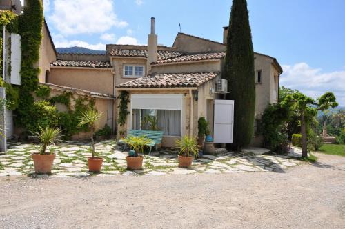 a house with potted plants in front of it at Le Jas Du Colombier in Moustiers-Sainte-Marie