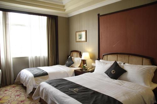 Habitación de hotel con 2 camas y ventana en The Royal Marina Plaza Hotel Guangzhou, en Guangzhou