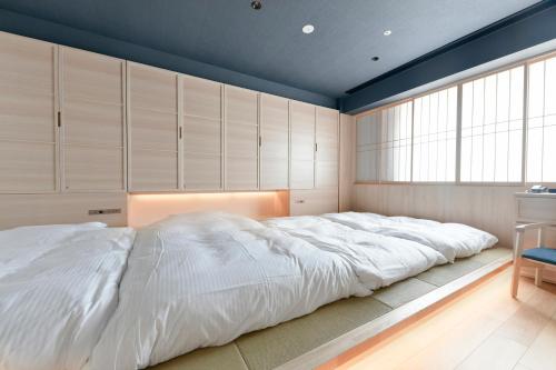 a large white bed in a room with cabinets at Vessel Hotel Campana Susukino in Sapporo