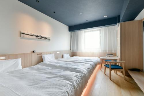 a large white bed in a room with a window at Vessel Hotel Campana Susukino in Sapporo