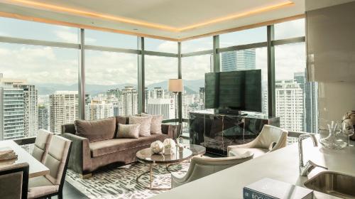 a living room with a couch and a television at Four Seasons Hotel Kuala Lumpur in Kuala Lumpur