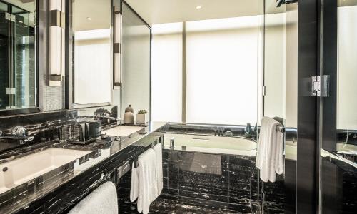 a bathroom with two sinks and a large mirror at Four Seasons Hotel Kuala Lumpur in Kuala Lumpur