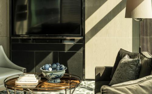 a living room with a table and a tv at Four Seasons Hotel Kuala Lumpur in Kuala Lumpur