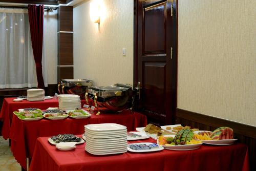 two tables with red table cloths with plates of food at Alpha Hotel Ulaanbaatar in Ulaanbaatar