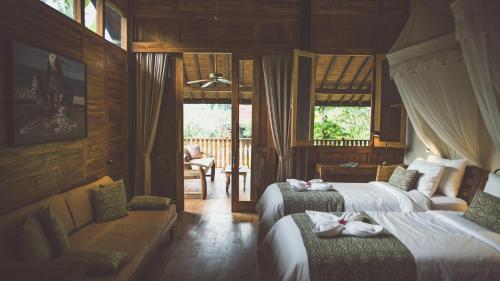 En eller flere senge i et værelse på Desa Saya Eco Luxury Resort & Spa