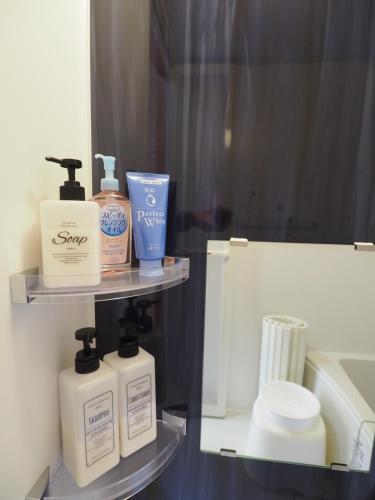 a shelf with soap and other toiletries in a bathroom at Mikan Hotel in Uwano